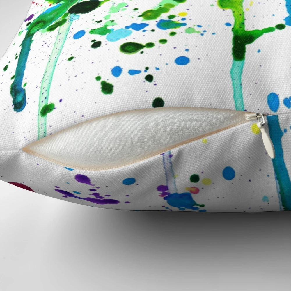 Colorful rainbow paint splatter and drip design on a decorative throw pillow