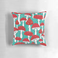 Artistic illustration of red mushrooms on a turquoise blue background, featured on a decorative pillow.