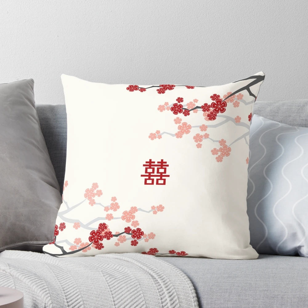 A decorative pillow featuring vibrant red cherry blossoms and oriental design elements.