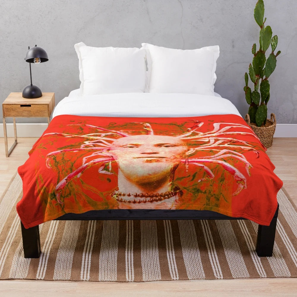 Closeup of a soft, plush blanket featuring a detailed red scorpion design in an abstract, mythological style