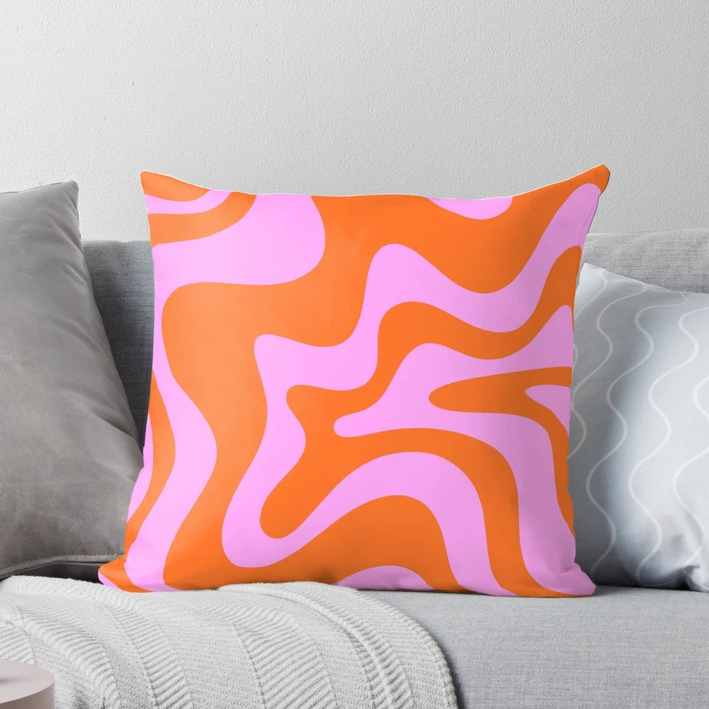Retro-inspired abstract pattern pillow in hot pink and red-orange with a vibrant swirling design.