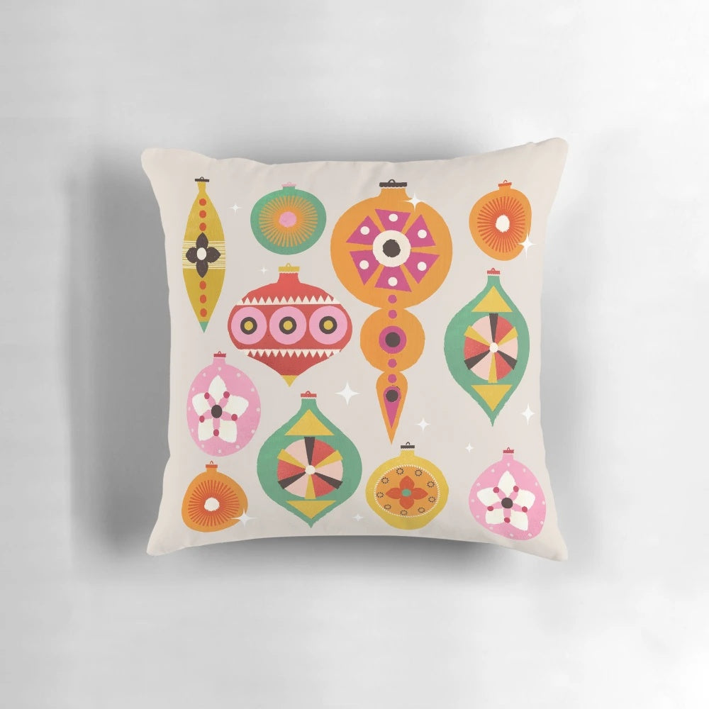 Closeup of a vintage-inspired Christmas tree ornament pillow with bright, colorful baubles and a retro design.