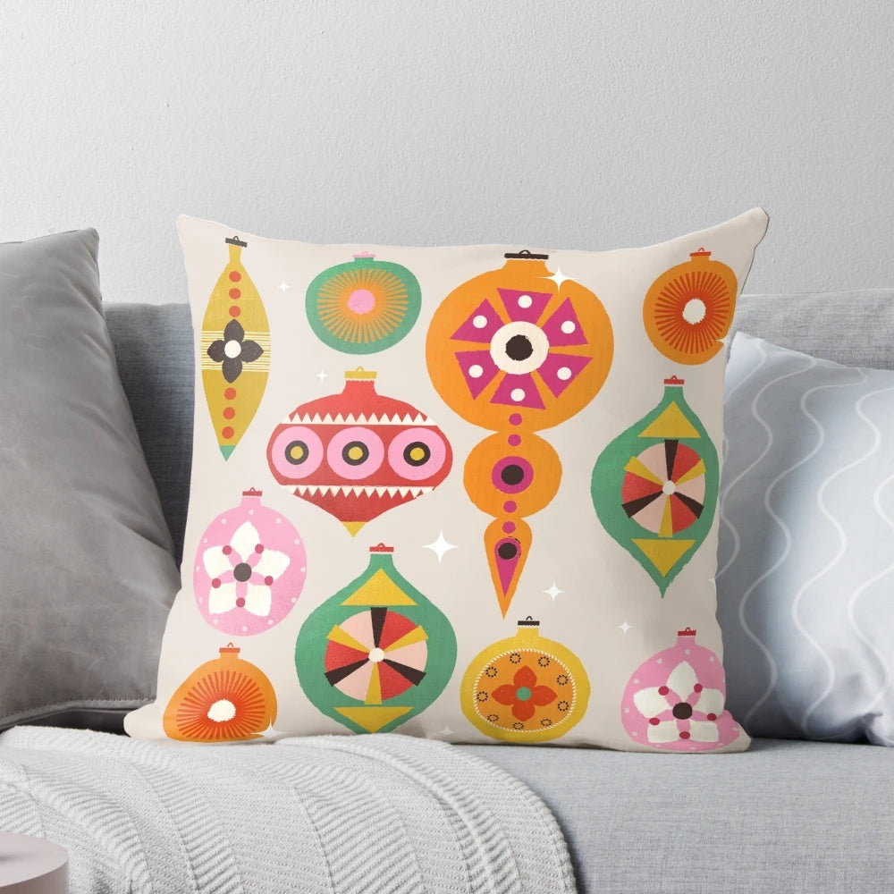 Closeup of a vintage-inspired Christmas tree ornament pillow with bright, colorful baubles and a retro design.