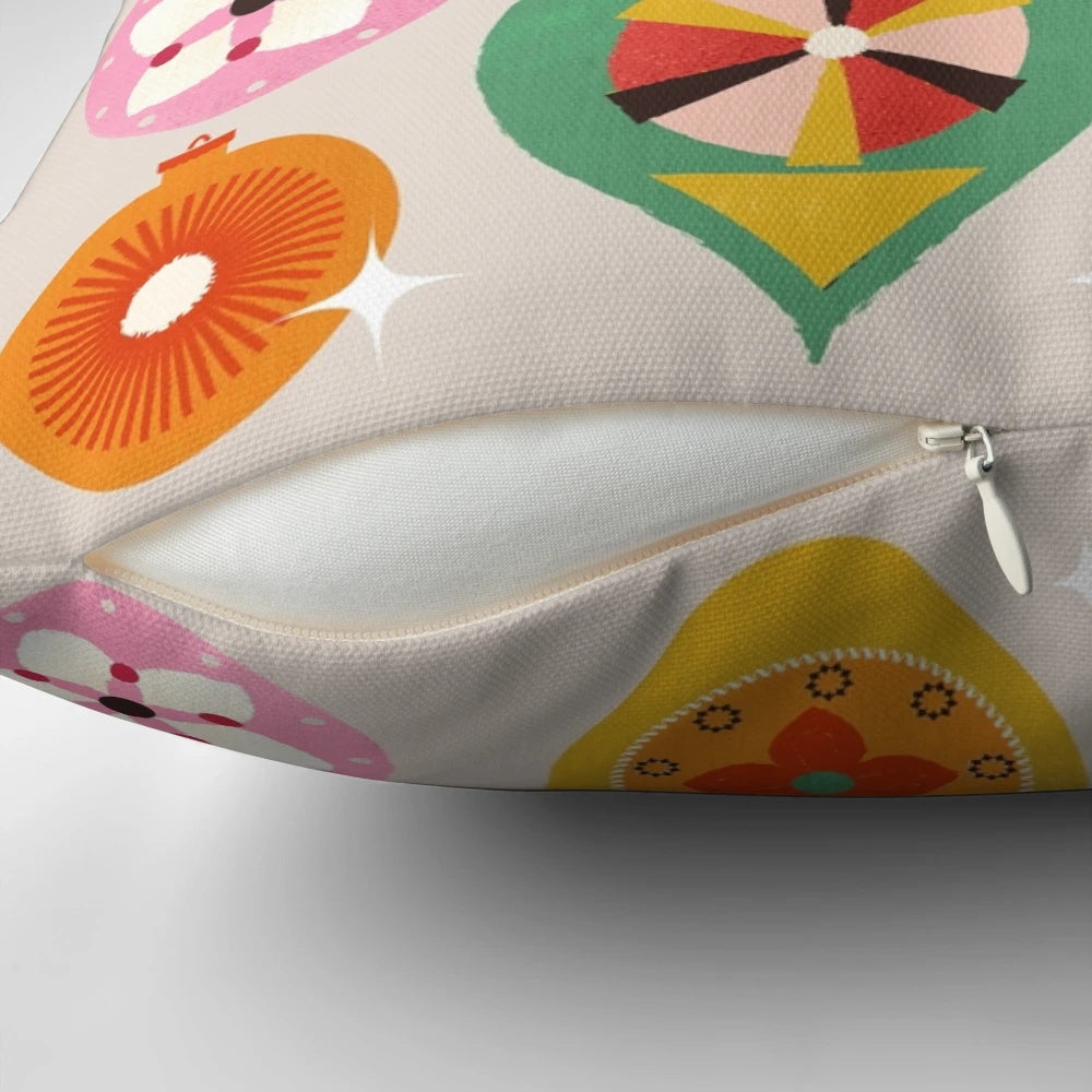 Closeup of a vintage-inspired Christmas tree ornament pillow with bright, colorful baubles and a retro design.