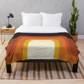 Midcentury modern plush blanket with a vibrant orange and rainbow geometric pattern