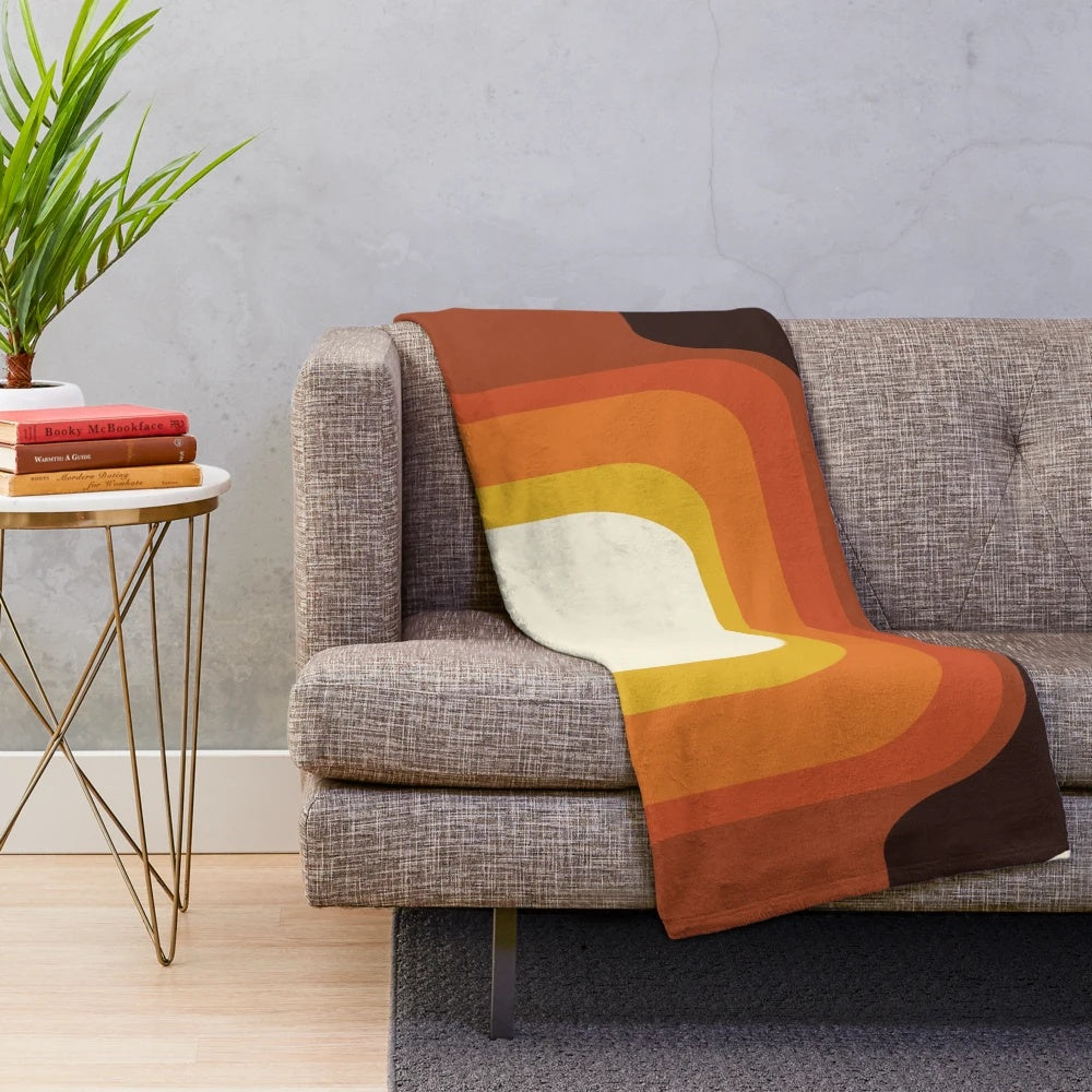 Midcentury modern plush blanket with a vibrant orange and rainbow geometric pattern