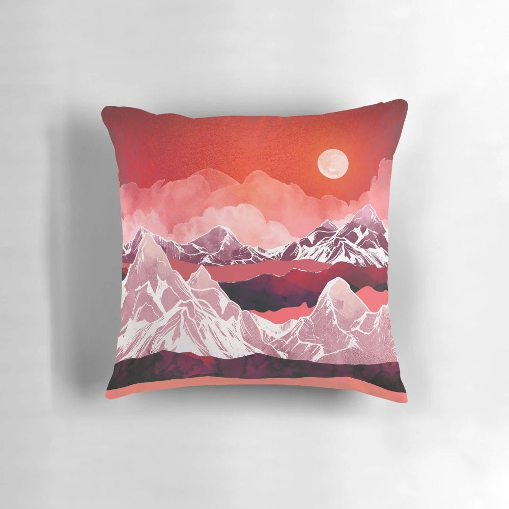 Scarlet, pink, and purple watercolor painting of a mountain landscape on a decorative throw pillow