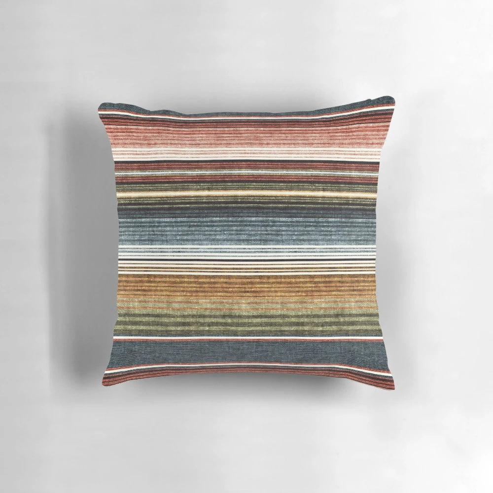 Decorative serape stripe pattern pillow in rust orange and blue colors