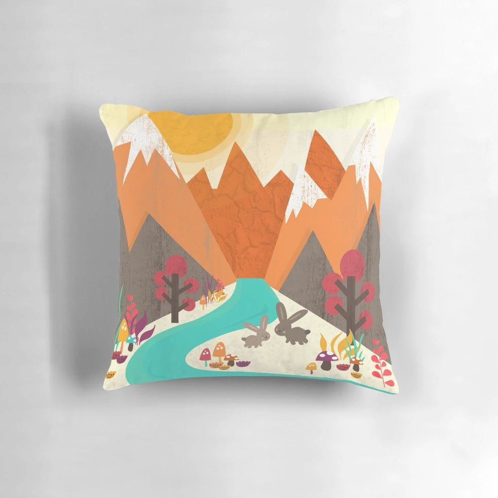 A colorful spring-themed pillow featuring a pastoral landscape with a rabbit, flowers, and a mountain in the background.