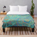 Soft plush blanket featuring a vibrant stained glass mandala design in teal, turquoise, and gold