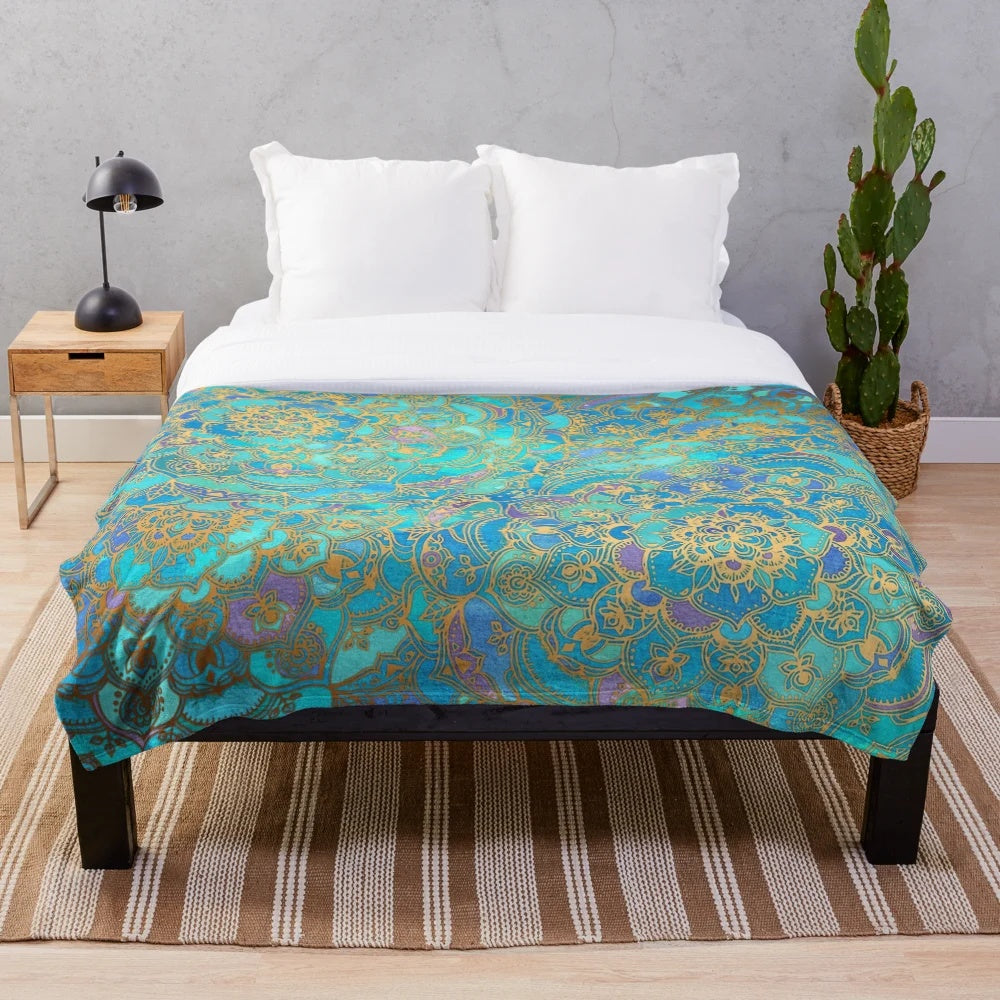 Soft plush blanket featuring a vibrant stained glass mandala design in teal, turquoise, and gold