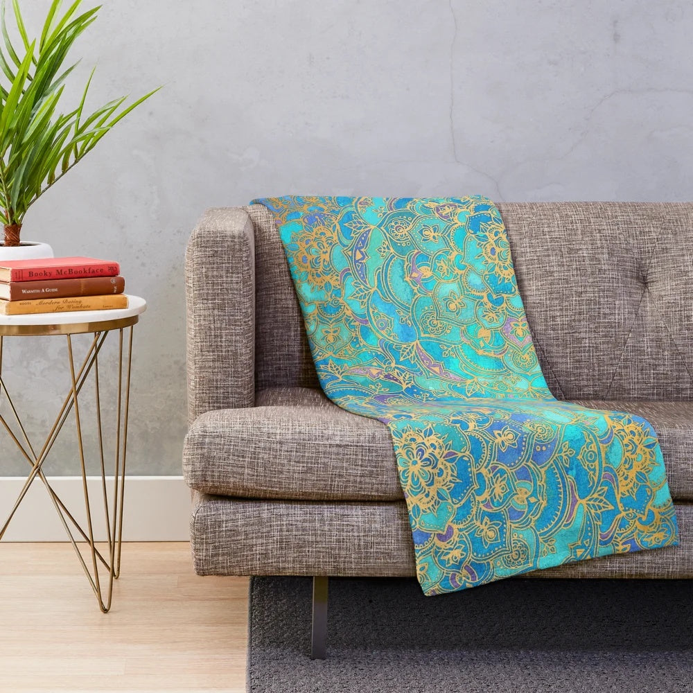 Soft plush blanket featuring a vibrant stained glass mandala design in teal, turquoise, and gold