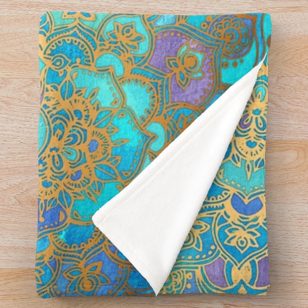 Soft plush blanket featuring a vibrant stained glass mandala design in teal, turquoise, and gold