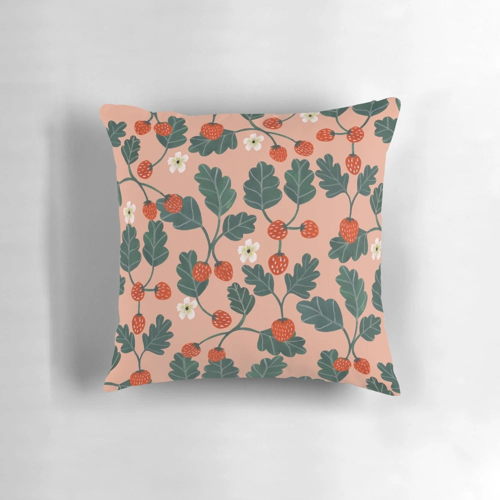 Closeup of a vibrant watercolor painting of strawberry blossoms on a decorative pillow