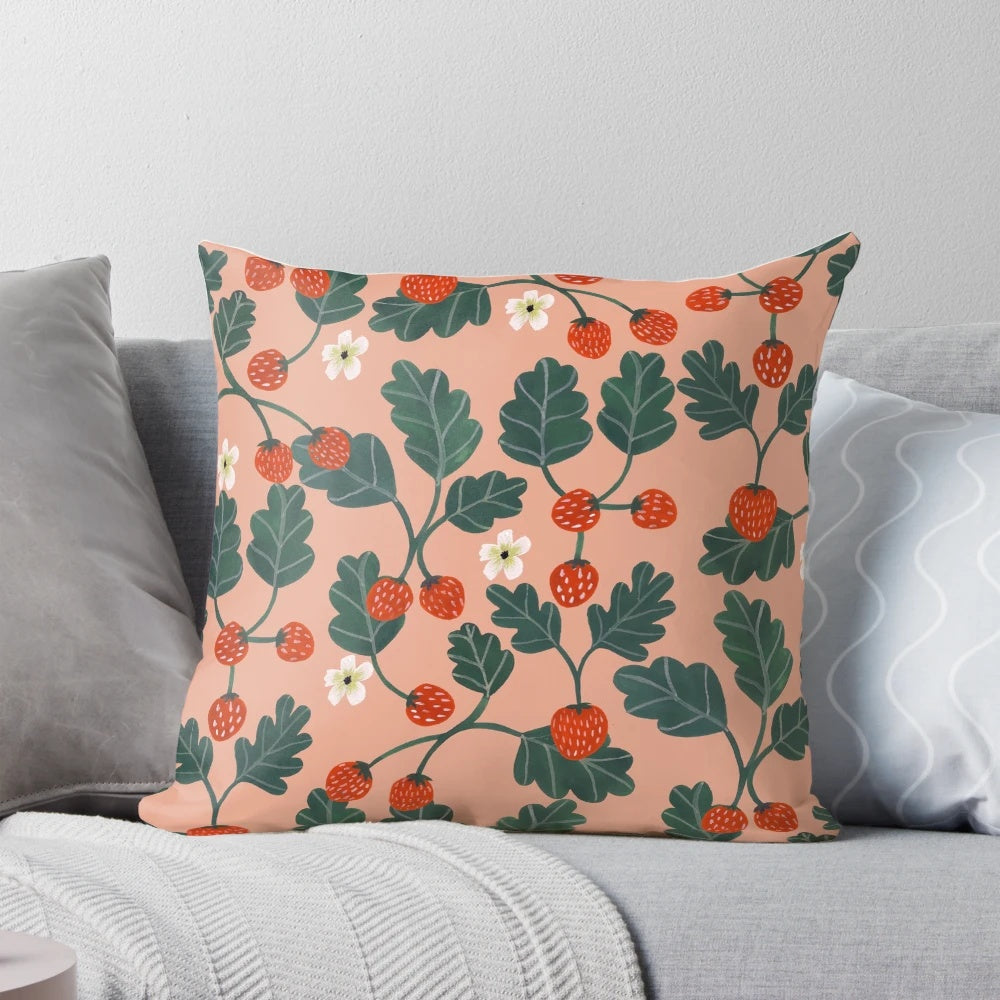Closeup of a vibrant watercolor painting of strawberry blossoms on a decorative pillow