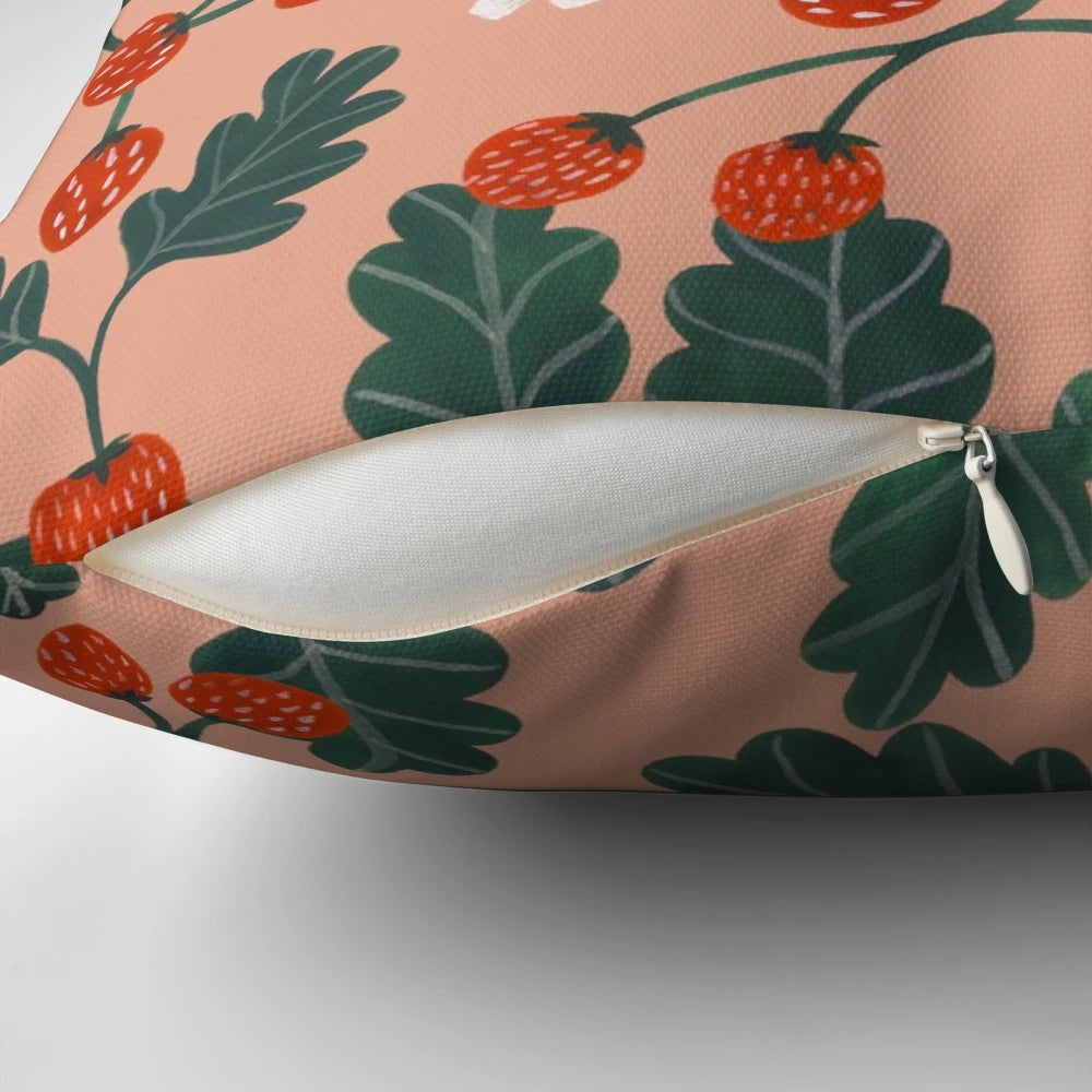 Closeup of a vibrant watercolor painting of strawberry blossoms on a decorative pillow