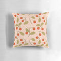 A close-up image of a soft, plush pillow featuring a vibrant strawberry pattern against a floral, botanical background.