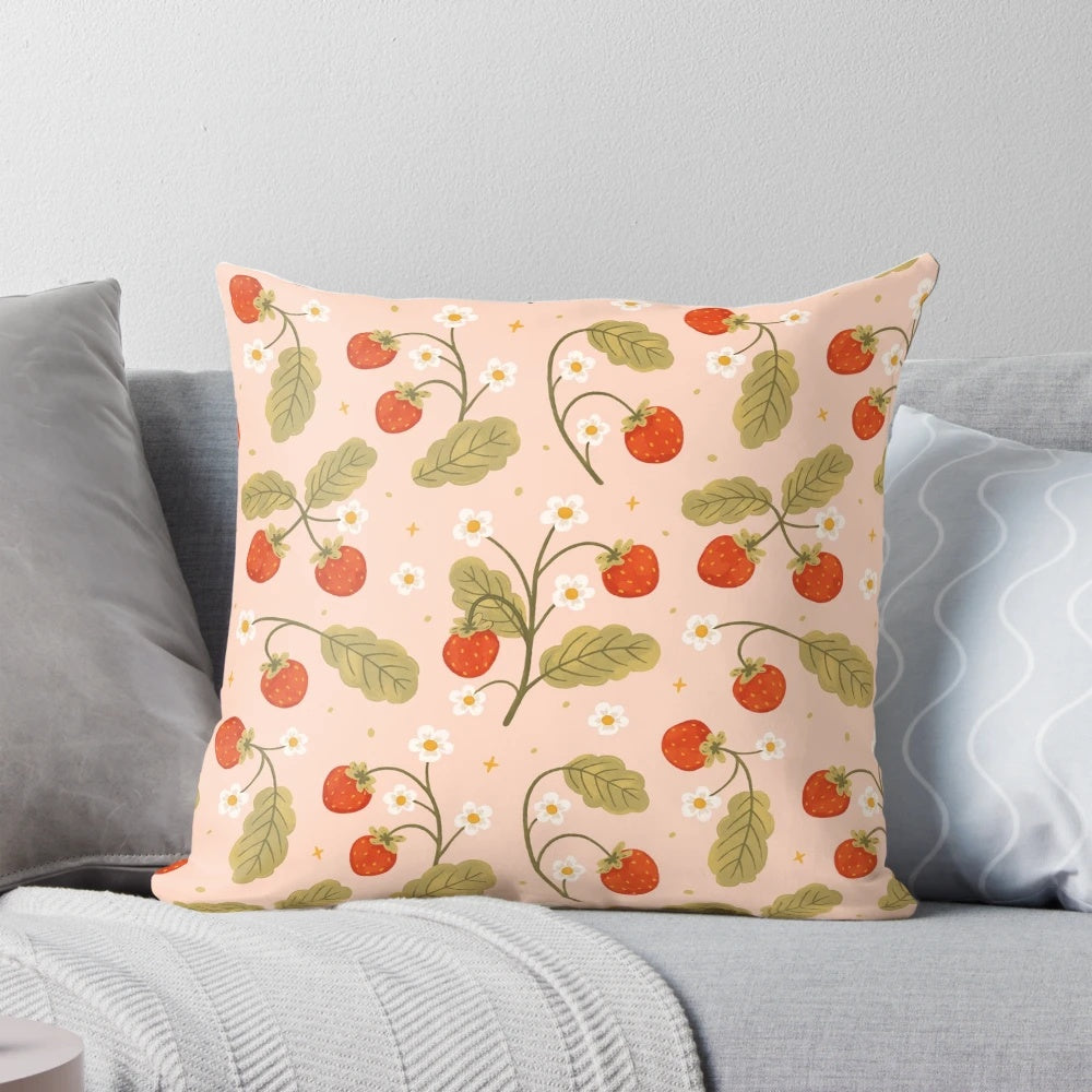A close-up image of a soft, plush pillow featuring a vibrant strawberry pattern against a floral, botanical background.