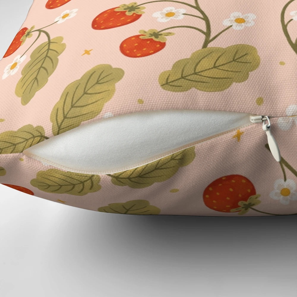 A close-up image of a soft, plush pillow featuring a vibrant strawberry pattern against a floral, botanical background.