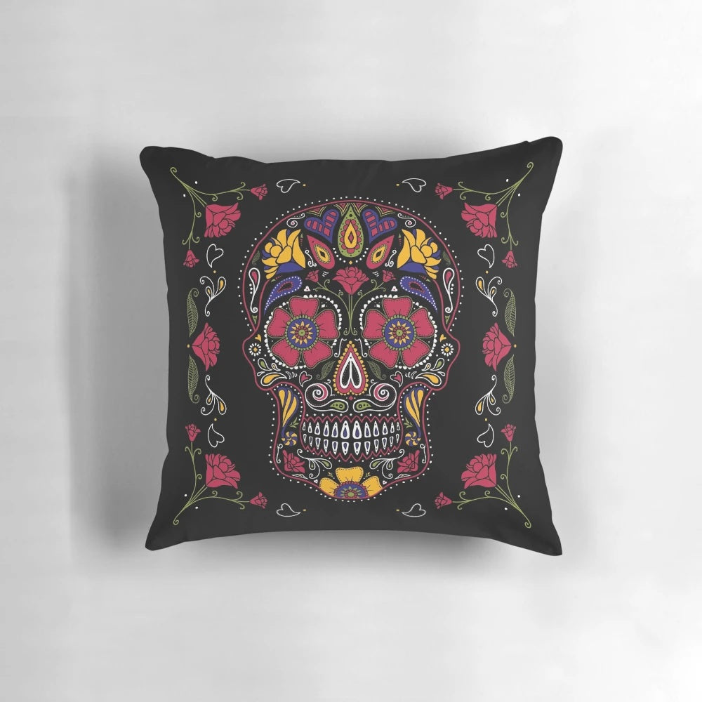 A dark, colorful sugar skull design pillow with floral and symmetrical patterns.