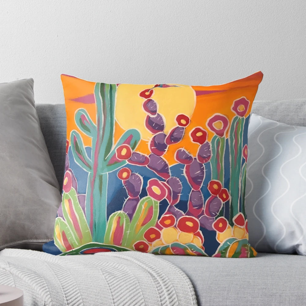 A vibrant sunset-inspired pillow featuring hummingbirds, cacti, and blooming flowers in a southwestern style.