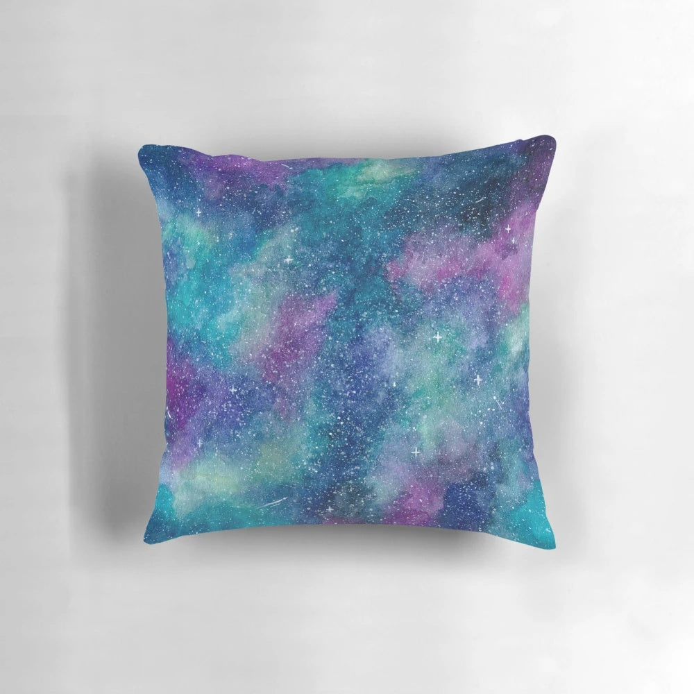 Teal, blue, and purple watercolor galaxy design on a square throw pillow