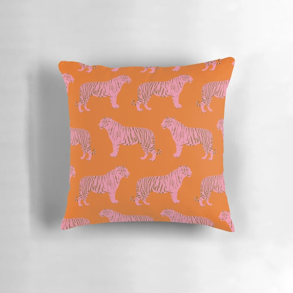 Closeup of a pink and orange pillow with a repeating tiger pattern, perfect for adding a touch of whimsy to any room.
