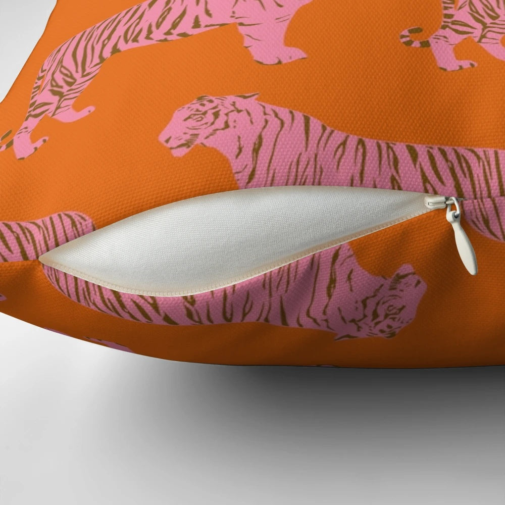 Closeup of a pink and orange pillow with a repeating tiger pattern, perfect for adding a touch of whimsy to any room.