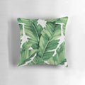 A vibrant, tropical-inspired pillow featuring a pattern of banana leaves.