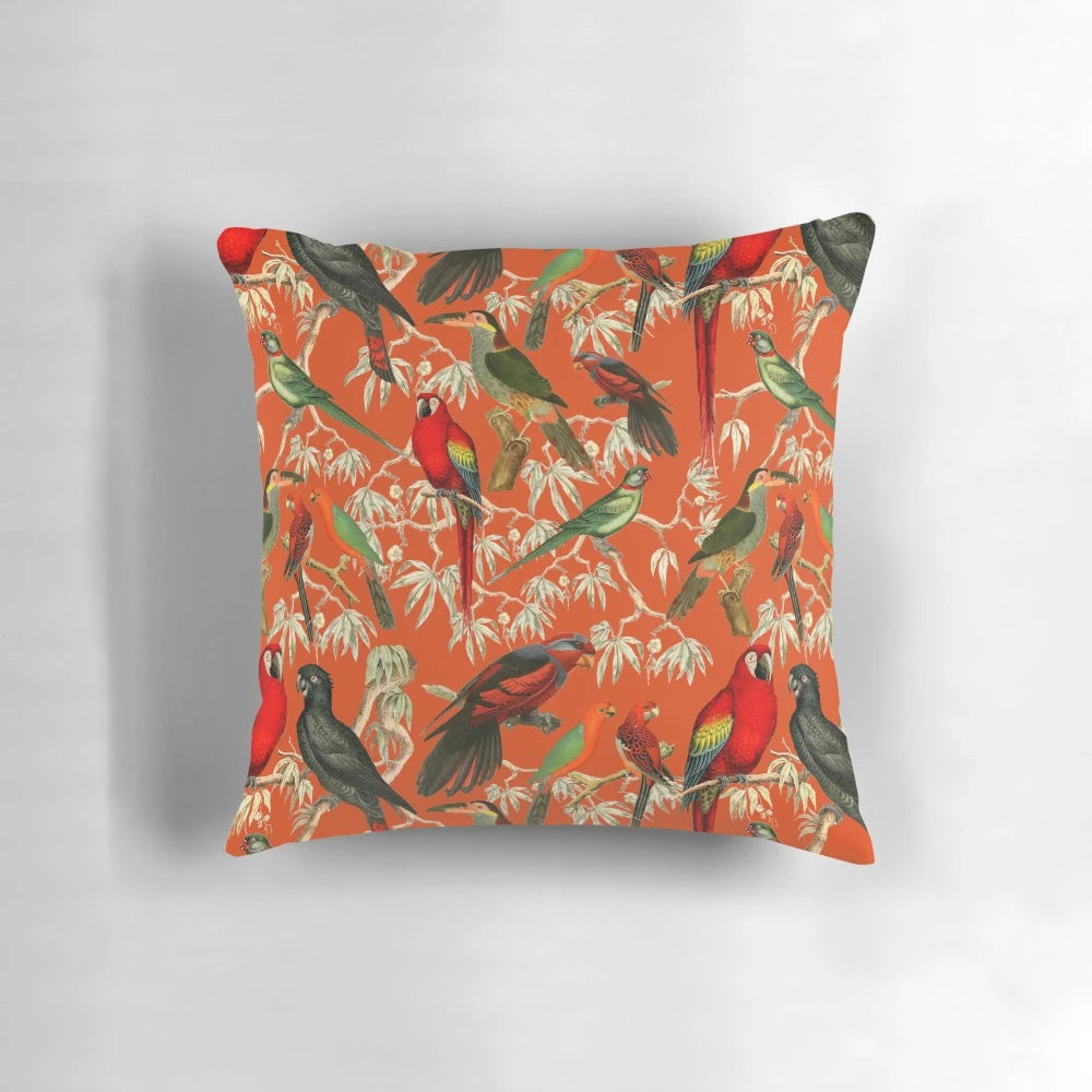 Vibrant orange and botanical patterned pillow featuring tropical birds