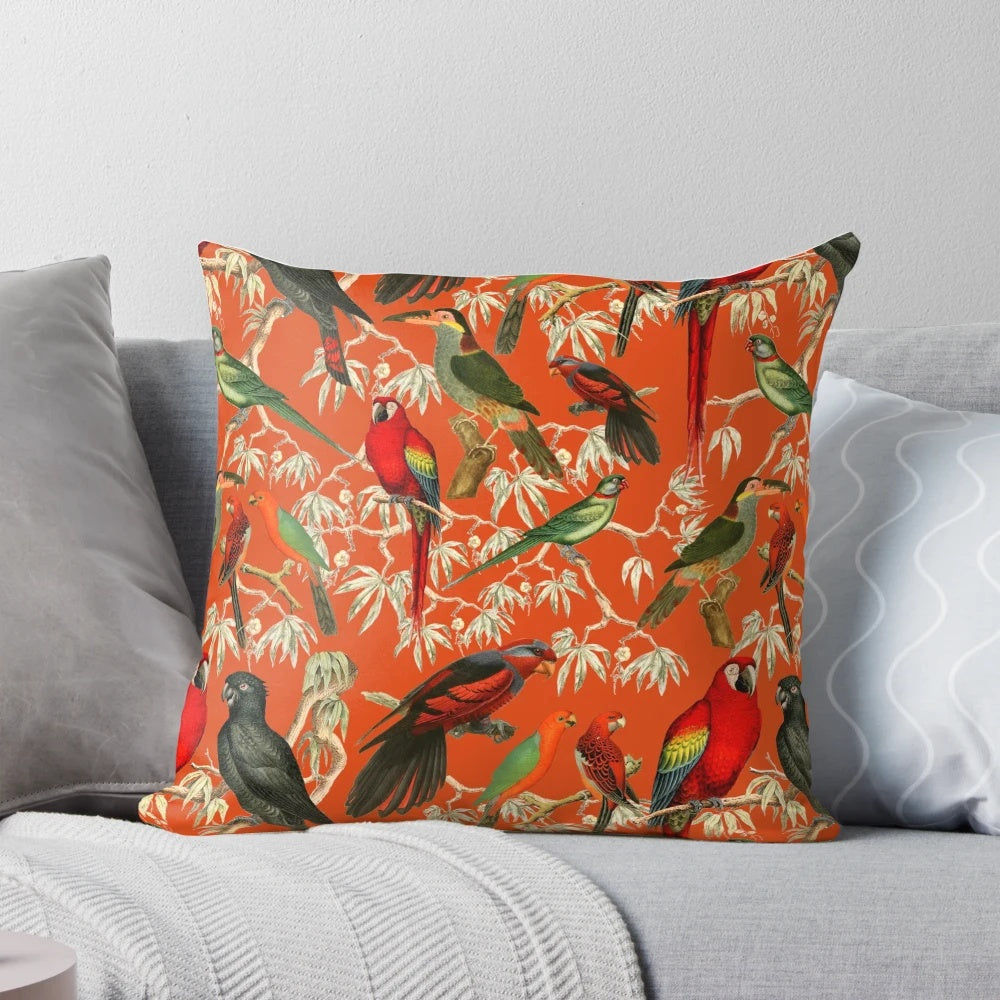 Vibrant orange and botanical patterned pillow featuring tropical birds