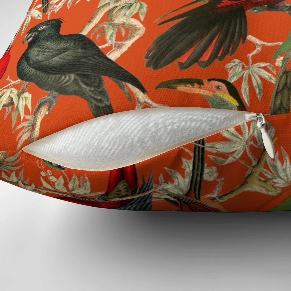 Vibrant orange and botanical patterned pillow featuring tropical birds