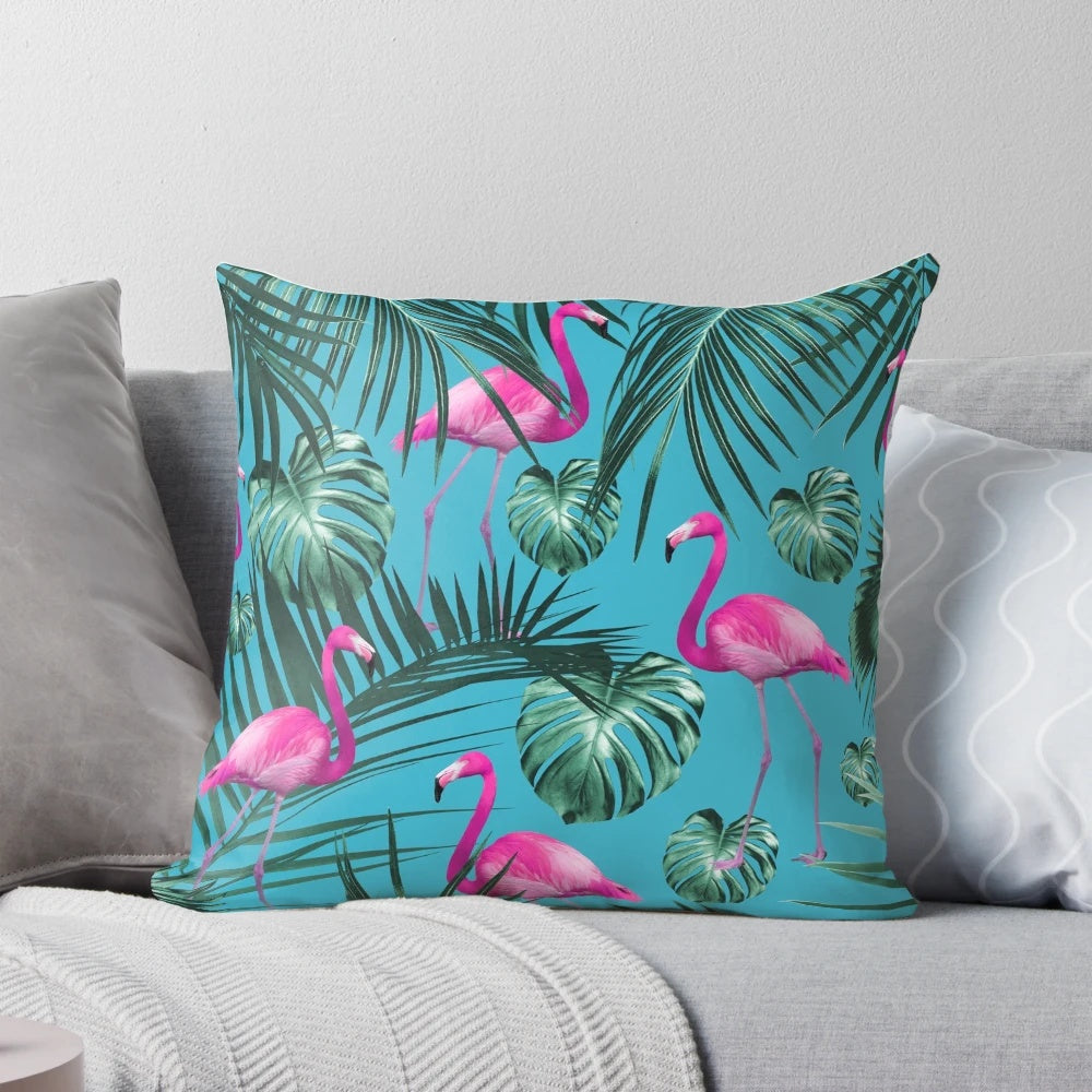 Tropical flamingo pattern pillow with colorful exotic leaves and foliage on an aqua blue background