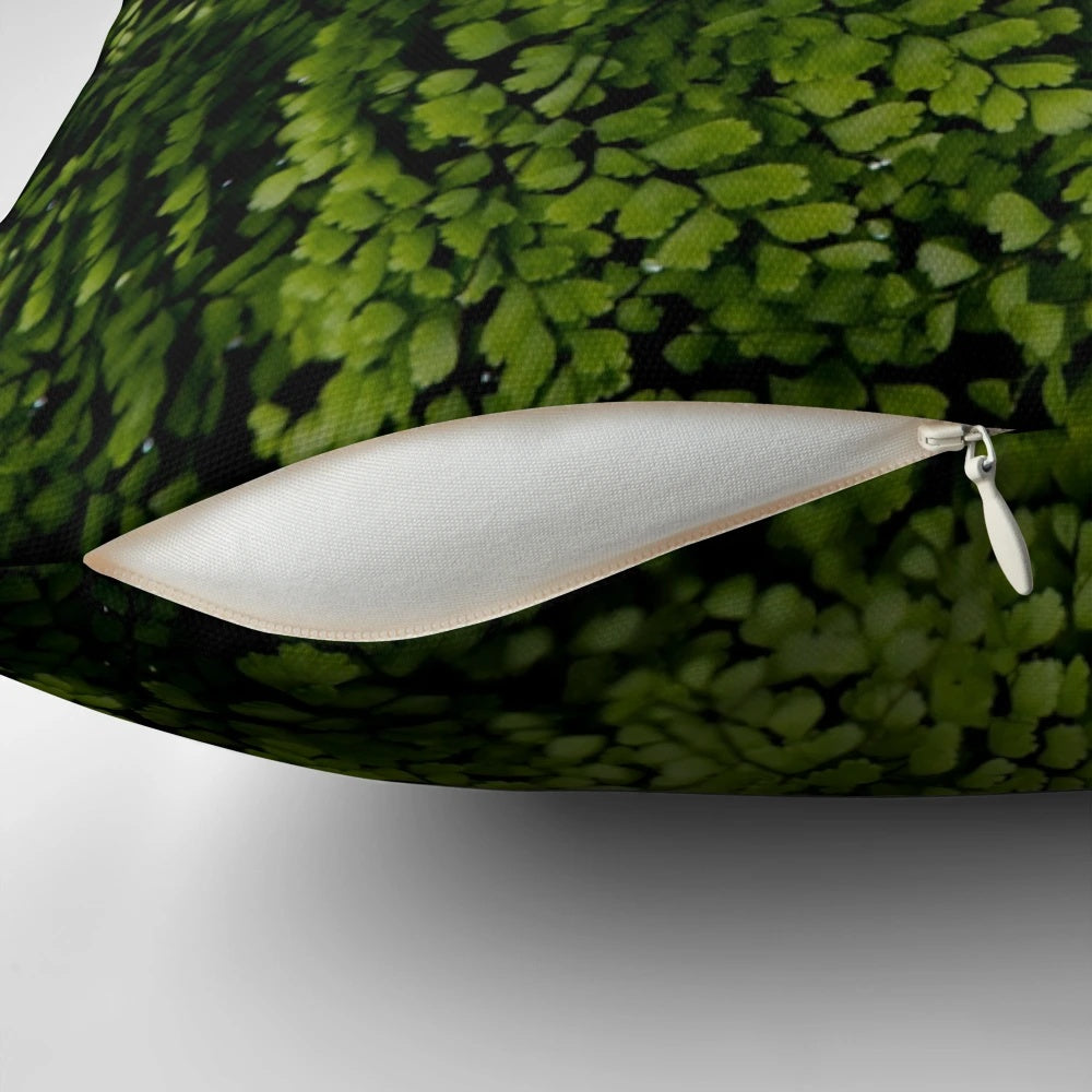 Closeup of small, green tropical leaves on a decorative pillow