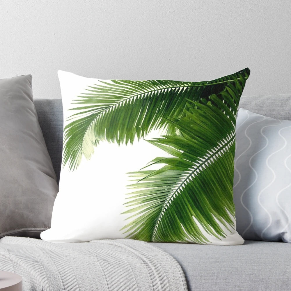 Decorative throw pillow featuring a watercolor design of lush, tropical palm leaves and greenery.