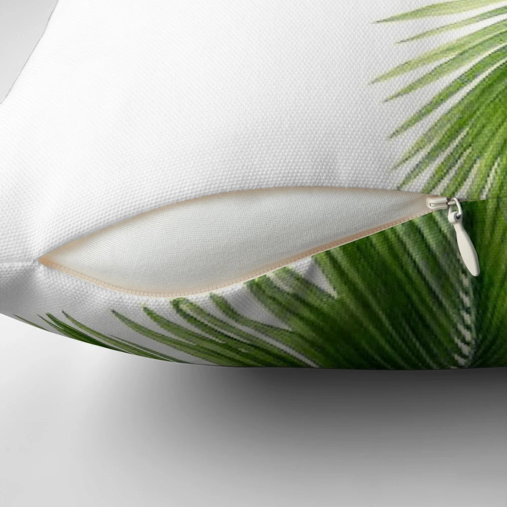 Decorative throw pillow featuring a watercolor design of lush, tropical palm leaves and greenery.