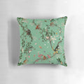 A lush, green pillow featuring a playful monkey design amidst a botanical, floral jungle pattern.
