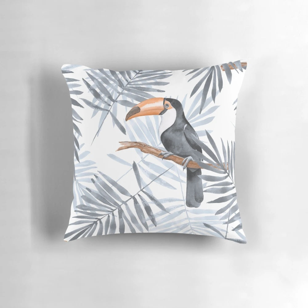 Decorative throw pillow featuring a vibrant watercolor pattern of tropical palm leaves and an exotic toucan bird.