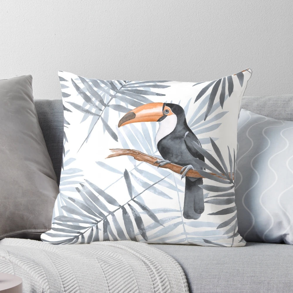 Decorative throw pillow featuring a vibrant watercolor pattern of tropical palm leaves and an exotic toucan bird.