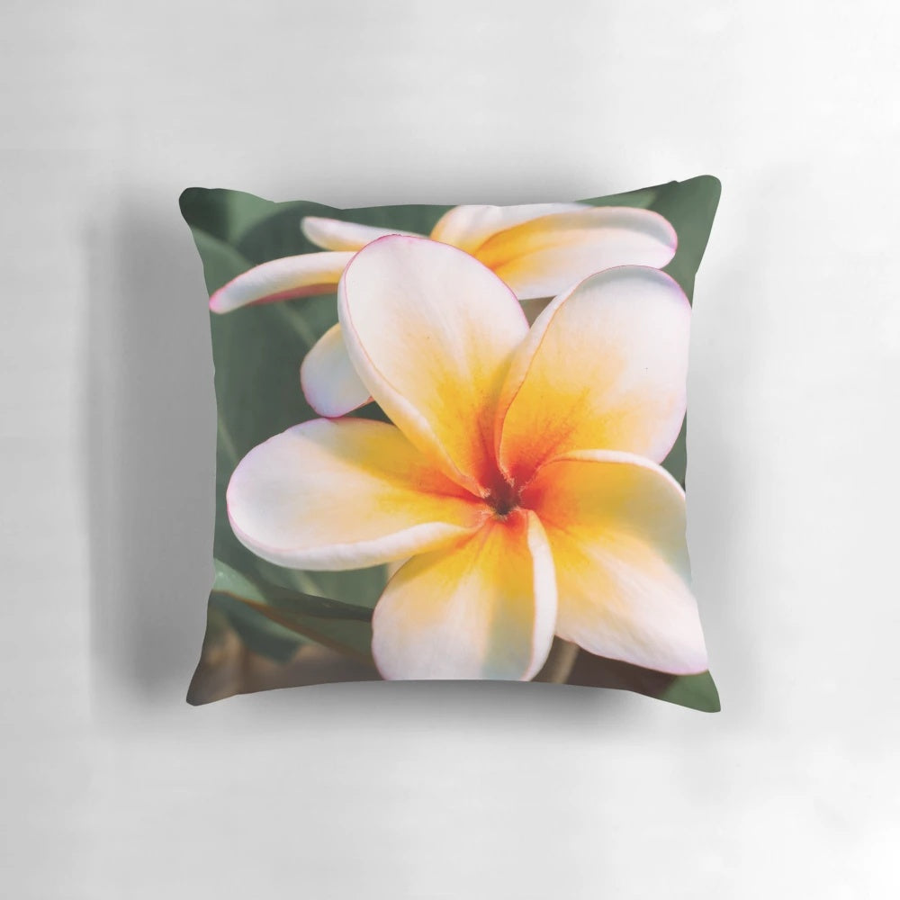 Pillow featuring vibrant orange plumeria or frangipani tropical flowers on a tree