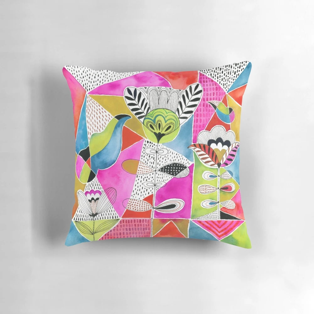 A colorful decorative pillow featuring a modern design of tulips and geometric triangles in a watercolor-inspired style.
