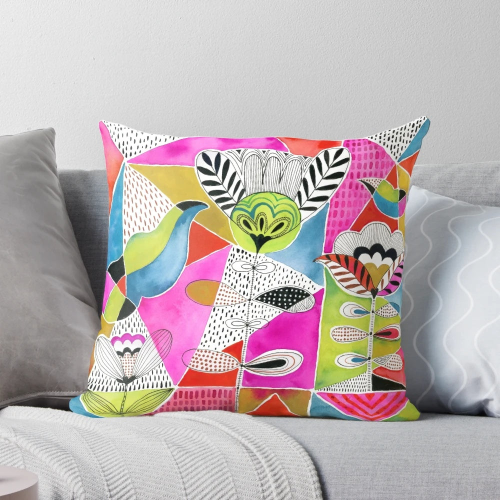 A colorful decorative pillow featuring a modern design of tulips and geometric triangles in a watercolor-inspired style.