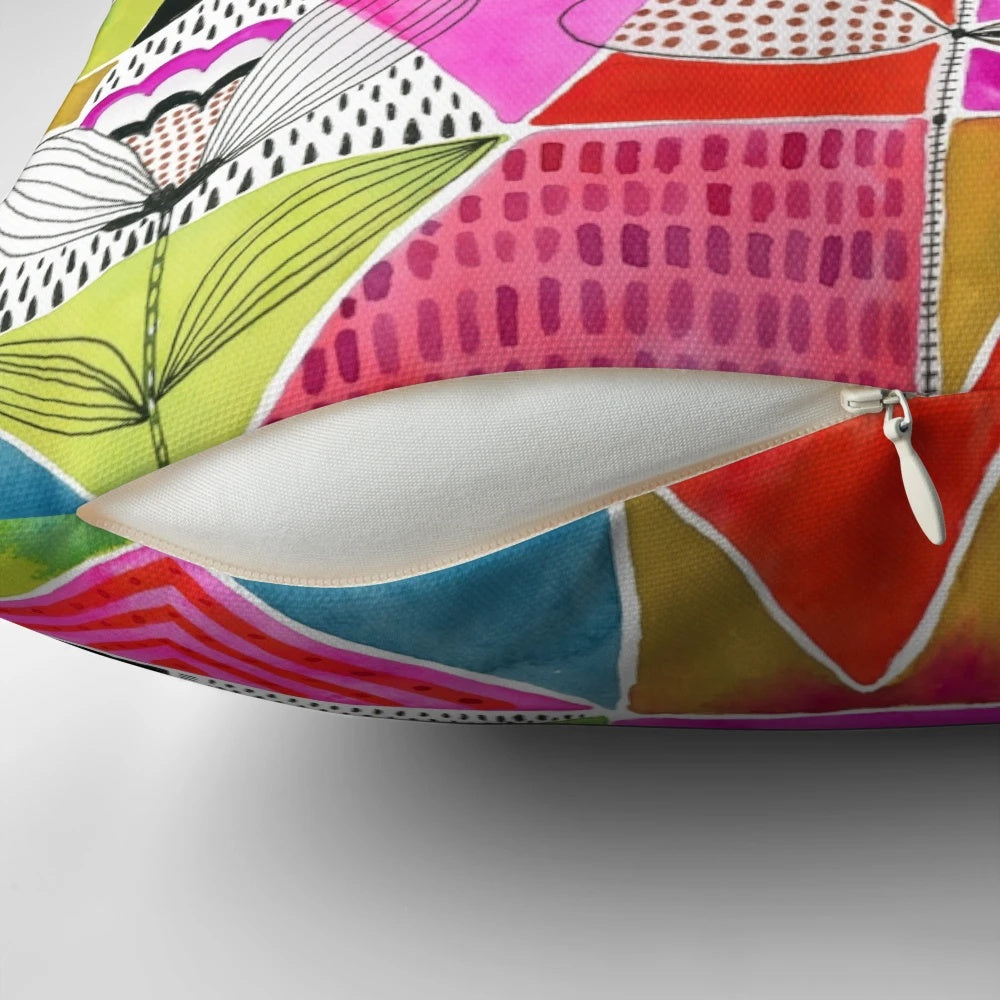 A colorful decorative pillow featuring a modern design of tulips and geometric triangles in a watercolor-inspired style.