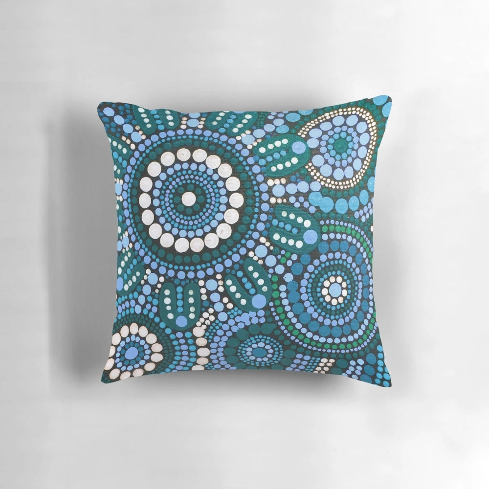 Colorful turquoise blue patterned throw pillow with Australian aboriginal-inspired design