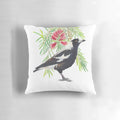 Colorful watercolor illustration of an Australian magpie bird perched on a bottlebrush tree branch with red flowers.