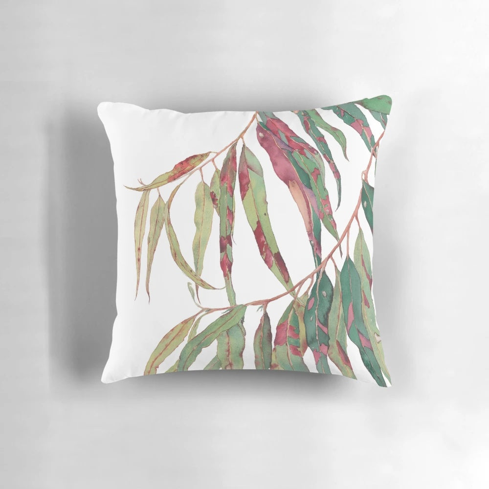 Watercolor painting of a eucalyptus branch with green and red leaves against a white background.