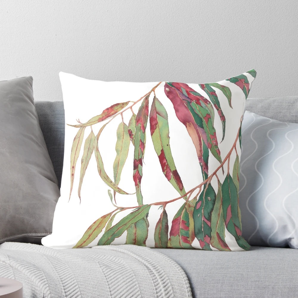 Watercolor painting of a eucalyptus branch with green and red leaves against a white background.
