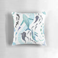 Colorful throw pillow featuring a watercolor design of sharks, whales, orcas, and sea turtles swimming in the ocean.