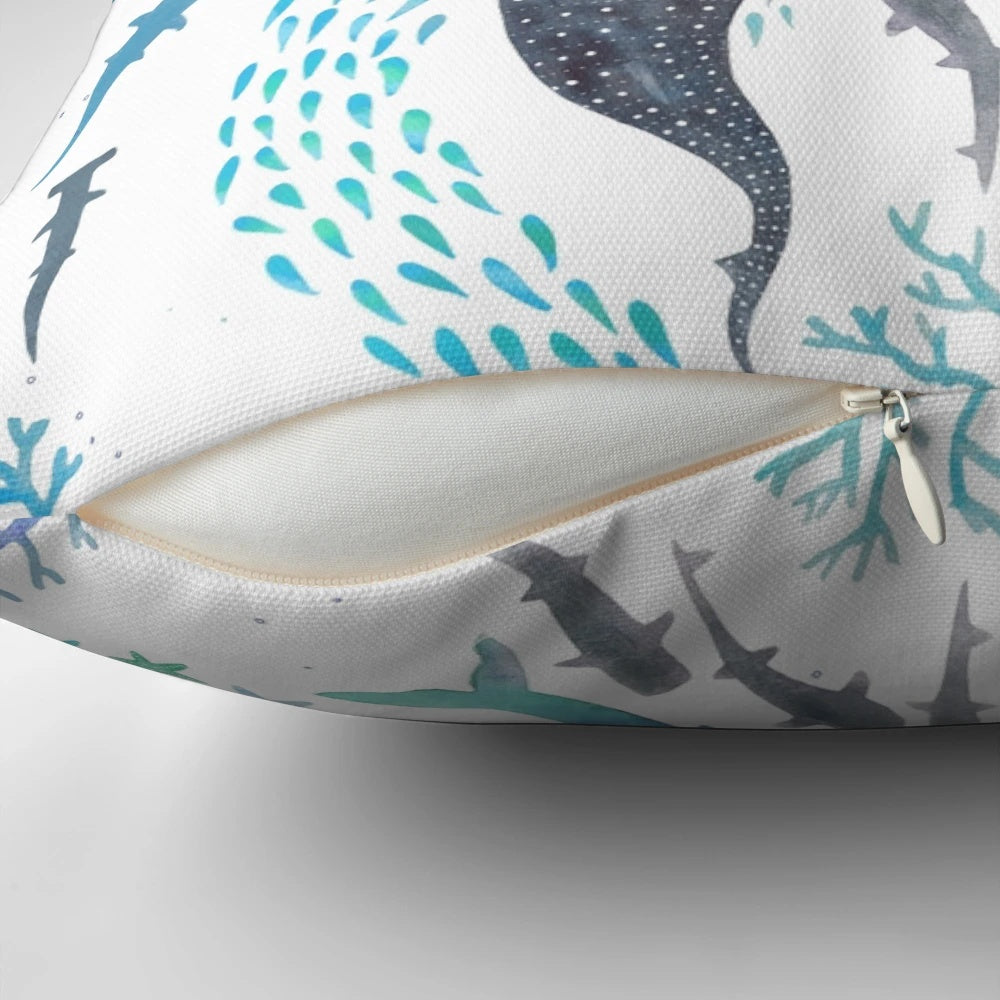 Colorful throw pillow featuring a watercolor design of sharks, whales, orcas, and sea turtles swimming in the ocean.