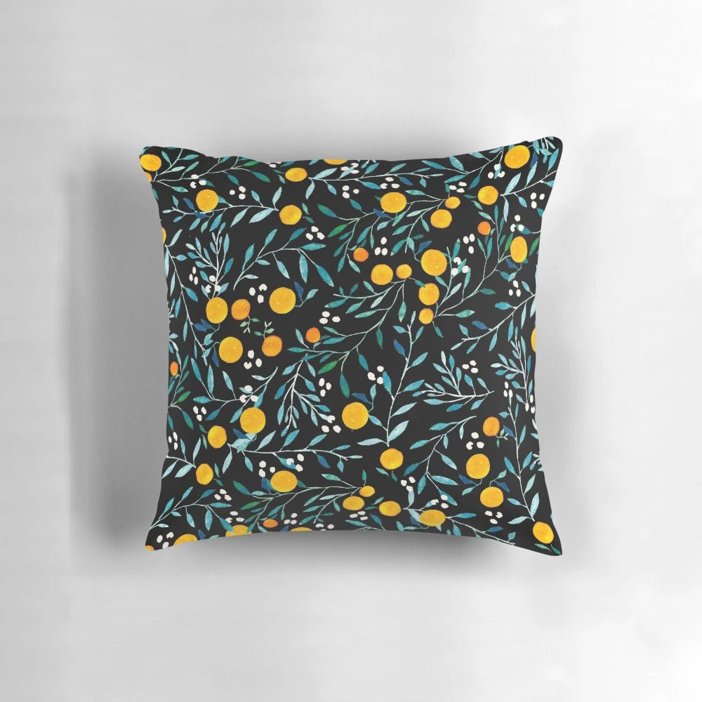 Pillow featuring a vibrant watercolor pattern of oranges and floral elements on a black background